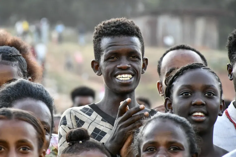 Man smiling among attendees at an In His Name Ministries gathering